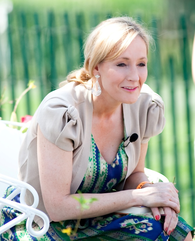 Joanne K. Rowling lehnt sich nach vorn und stützt sich auf den Ellbogen ab. Sie lächelt.