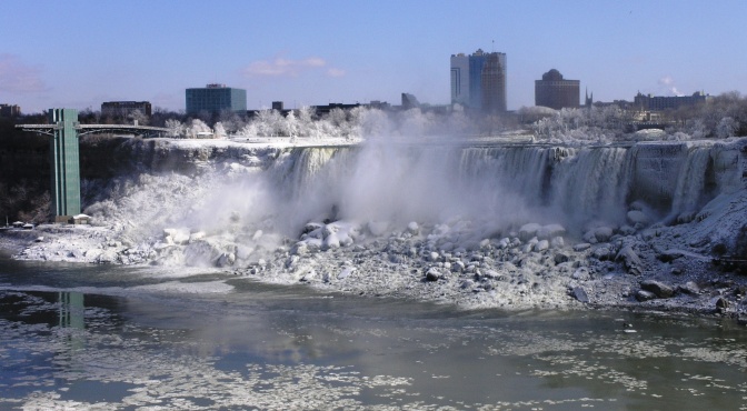 Die Niagarafälle im Winter. Auf dem Wasser sieht man kleine Eisschollen.