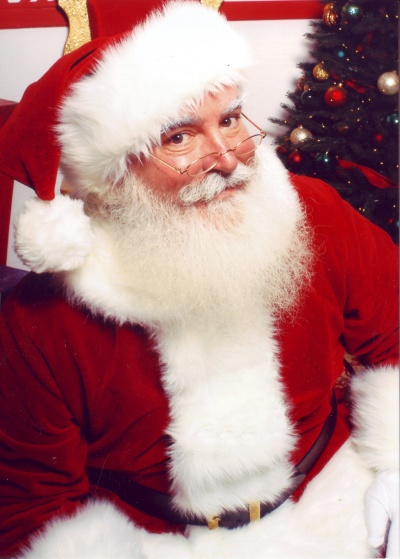 Ein Mann mit weißem Vollbart in Weihnachtsmannkostüm