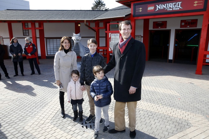 Ein Elternpaar mit 2 Söhnen und einer Tochter. Sie tragen Jacken und stehen im Freien zusammen.