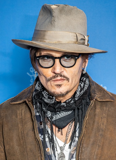 Johnny Depp mit einer schwarzen Brille, Schnauzbart und Hut.
