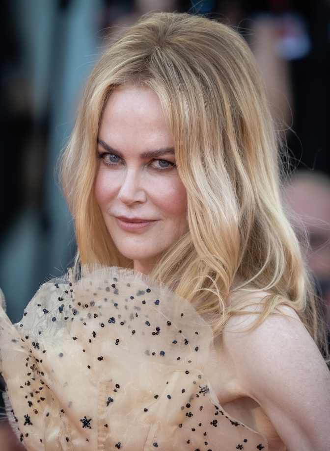 Nicole Kidman mit langen blonden Haaren in einem eleganten Kleid mit Tupfen.