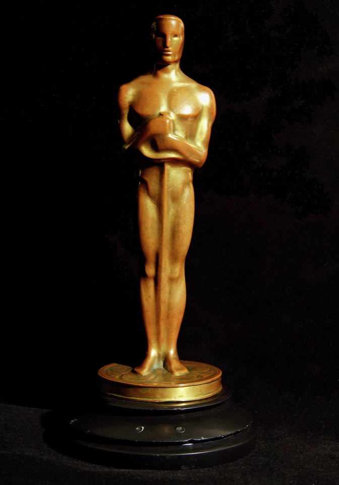 Die Oscar Statue: Eine vergoldete männliche Figur, die sich auf ein Schwert stützt.