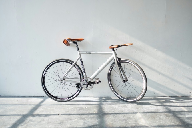 Ein Herrenfahrrad lehnt an einer weißen Wand.