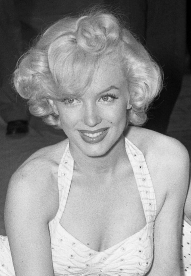 Schwarz-weiß-Foto von Marilyn Monroe in einem Neckholderkleid mit blonden, in Wellen gelegten Haaren