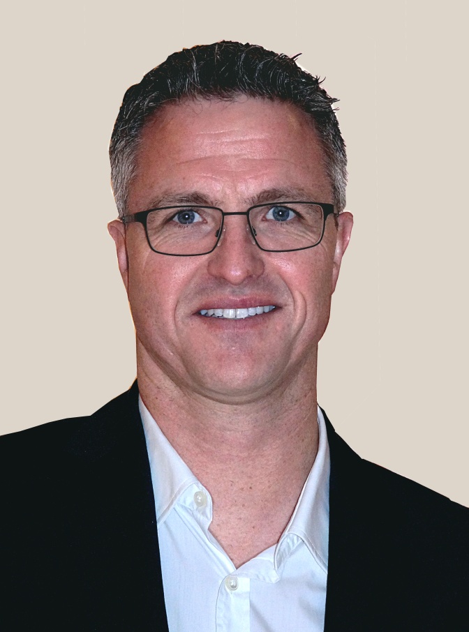 Ralf Schumacher mit kurzen Haaren und Brille. Er lächelt in die Kamera.