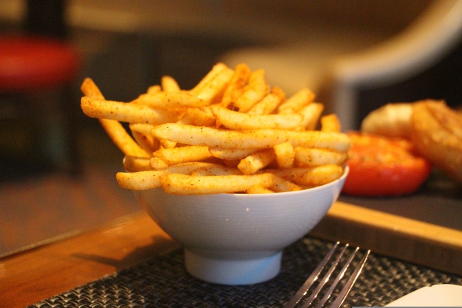Eine Schale mit Pommes auf einem Tisch.