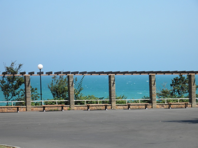 Der Strand von Burgas. Man sieht das Meer durch einen Laubengang mit Bänken.