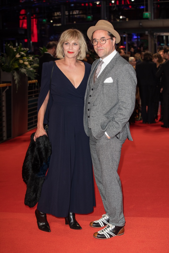 Jan Josef Liefers und Anna Loos in eleganter Kleidung auf dem roten Teppich.