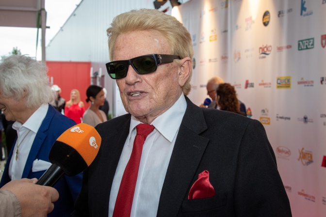 Heino mit großer schwarzer Sonnenbrille. Er spricht in ein Mikro des ZDF.