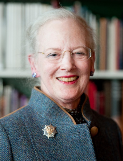 Königin Margarethe von Dänemark steht vor einem Bücherregal