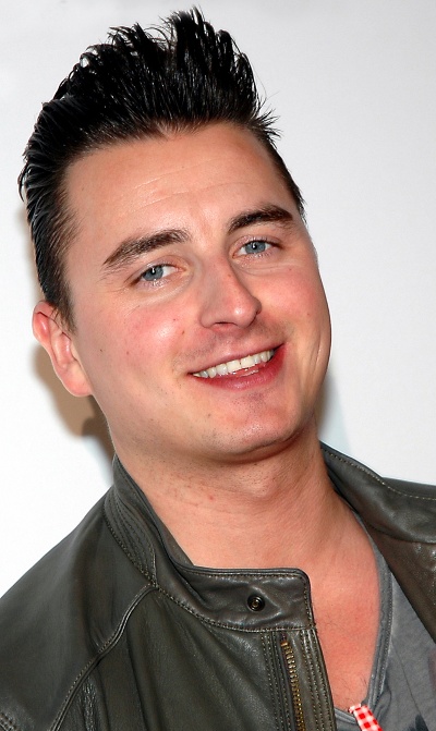 Andreas Gabalier mit kurzen, dunklen, nach oben gegelten Haaren und in schwarzer Lederjacke. Er lächelt in die Kamera.