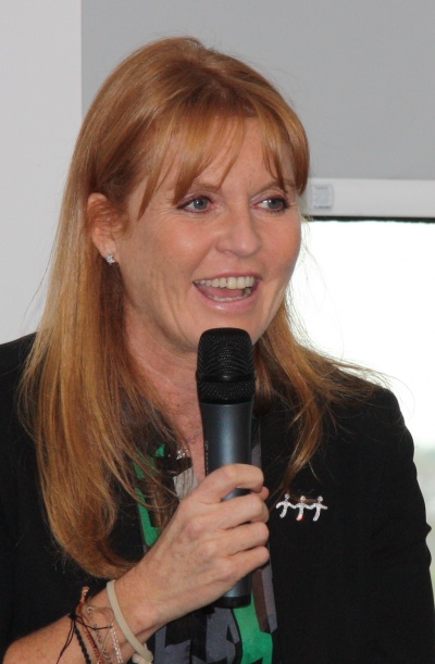 Sarah Ferguson mit langen, glatten roten Haaren. Sie spricht in ein Handmikro.