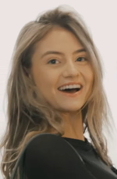 Leni Klum schaut über ihre Schulter hinweg direkt in die Kamera und lächelt.