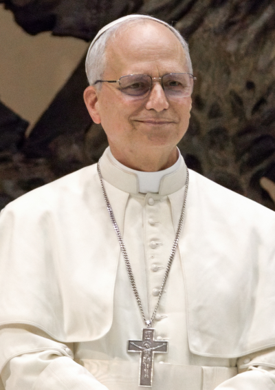 Papst Leo in weißer Kleidung mit einer kleinen Kappe auf dem Hinterkopf und einer großen Kette mit einem goldenen Kreuz.